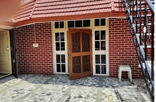 Kuvempu Nagara Apartment | Open front yard with mature trees for relaxation.